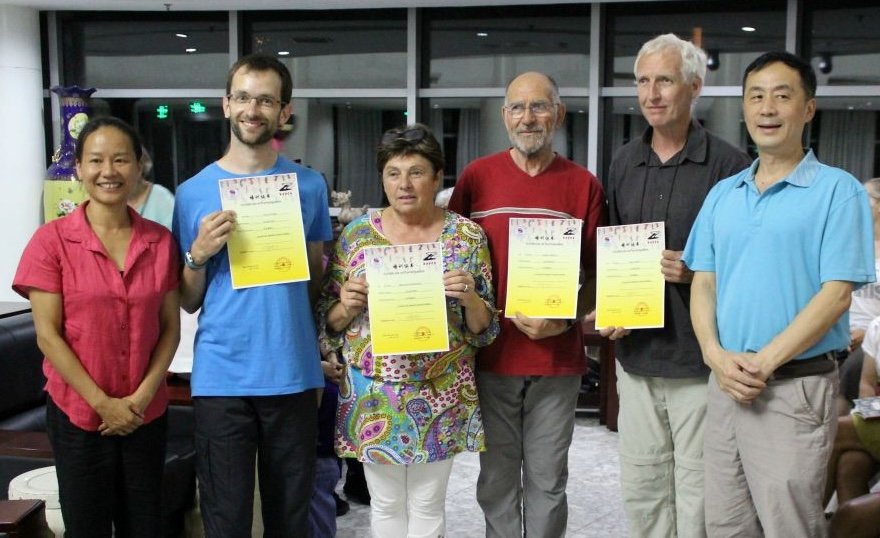 Hu Laoshi aux côtés de pratiquants présentant leurs certificats